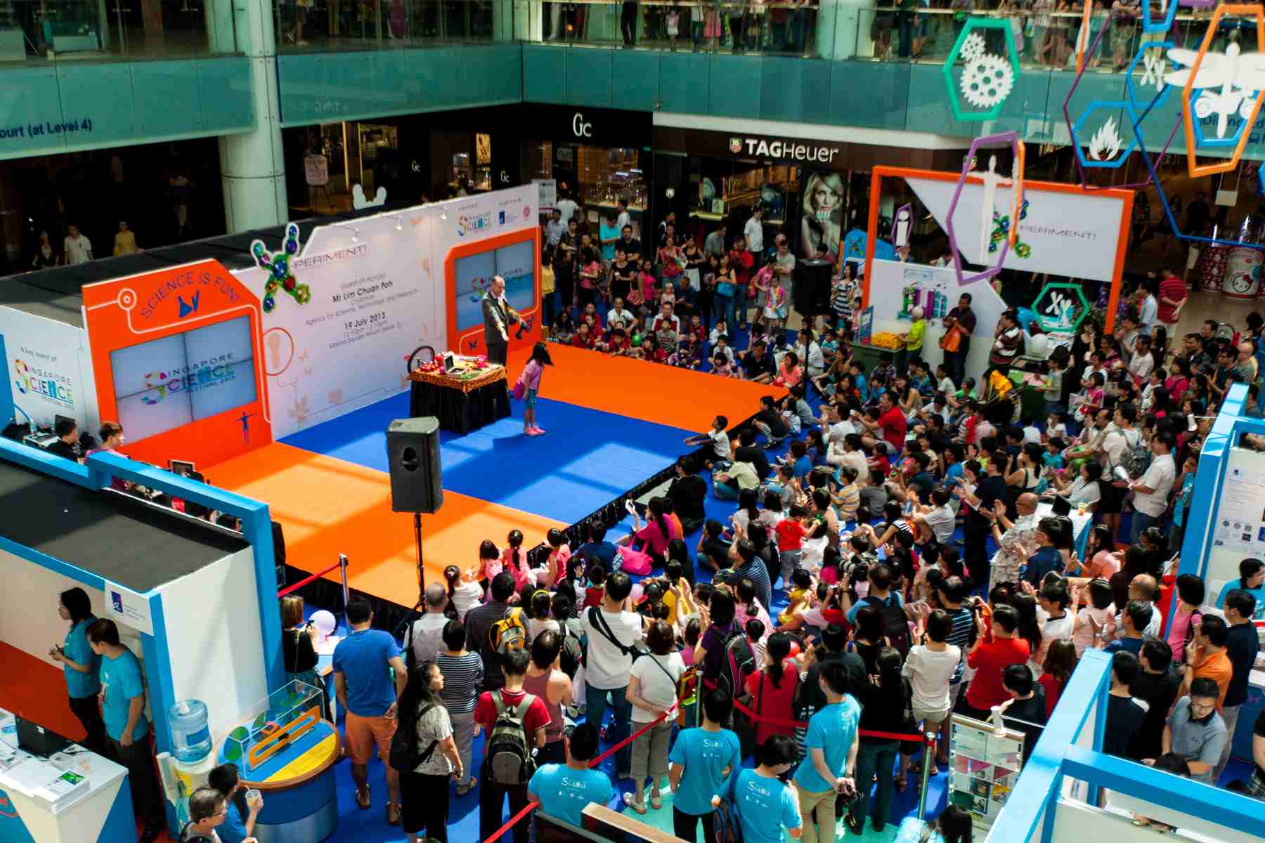 Dr Ken on stage at the Central Atrium in Marina Square Singapore Science festival. A young volunteer bows to an appreciative audience.