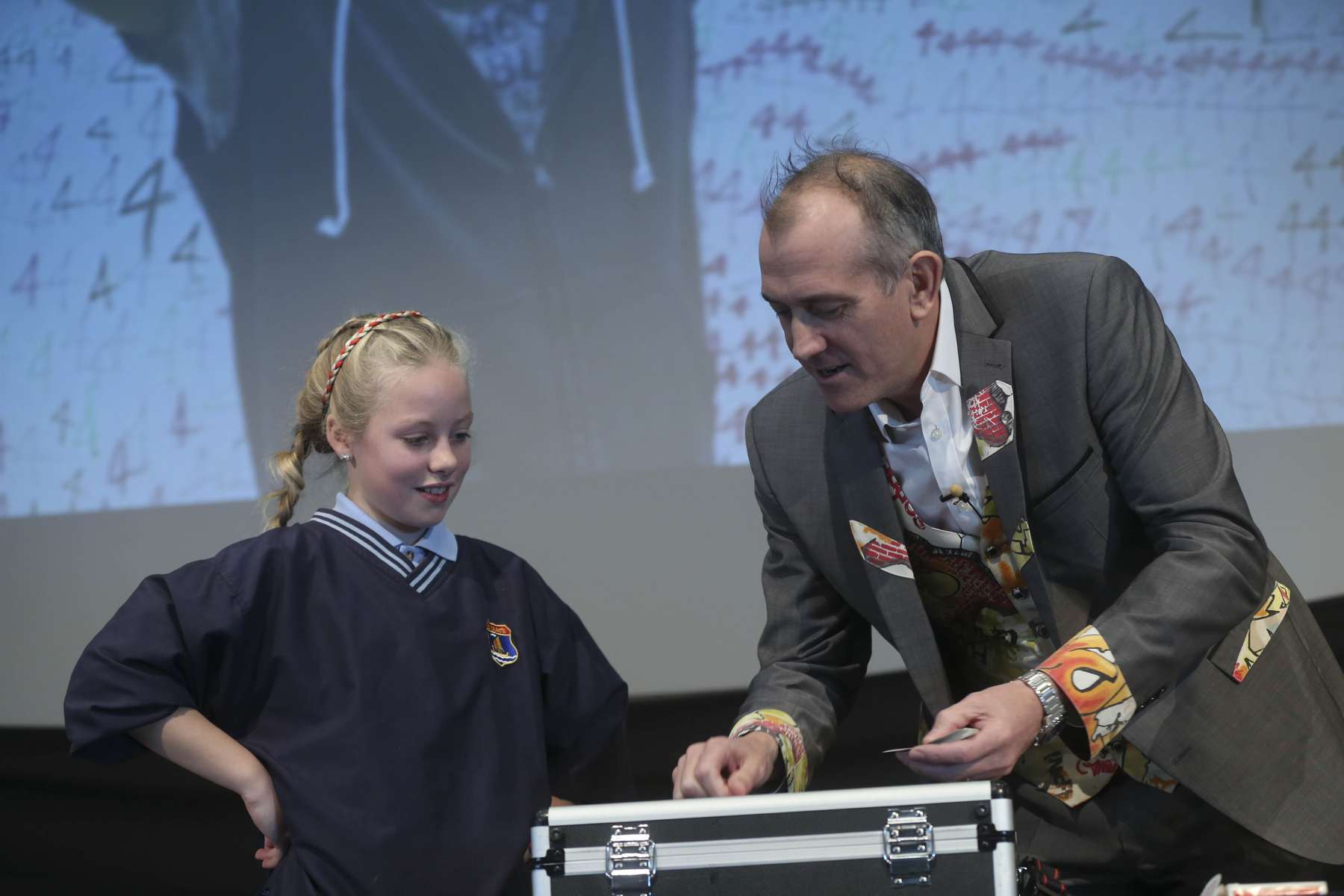 A Pupil watch Dr Ken count out their selected number of cards onto a briefcase.