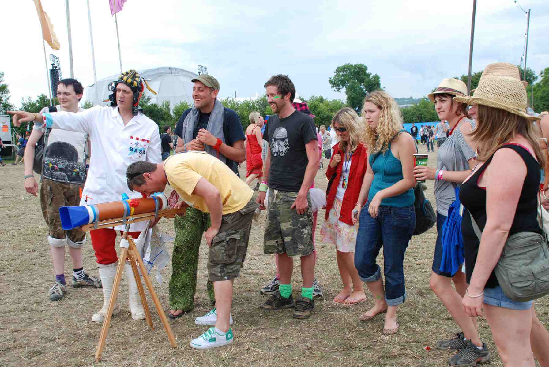 Glastonbury Festival Walkabout Sky at Day Glastonbury audiences queue to see how a telescope works during the day in the theatre and circus fields of the Glastonbury festival.