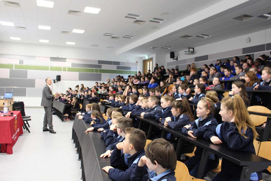 200 Pupils from local primary schools are seated in a lecture theatre watching Dr Ken's Magic science show.