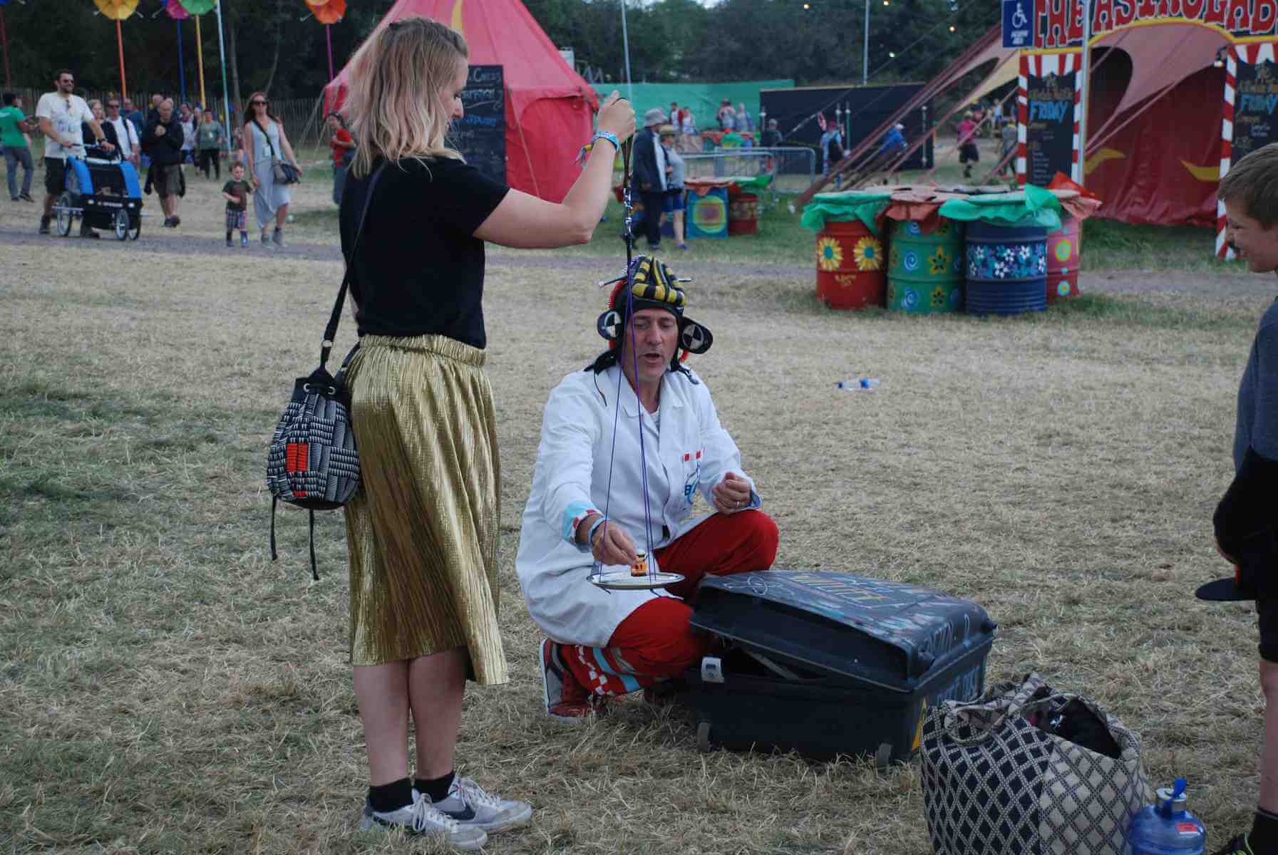 In this science busking walkabout a volunteer holds a rope which has a tray attached. Dr Ken is placing a small toy astronaut on the tray.