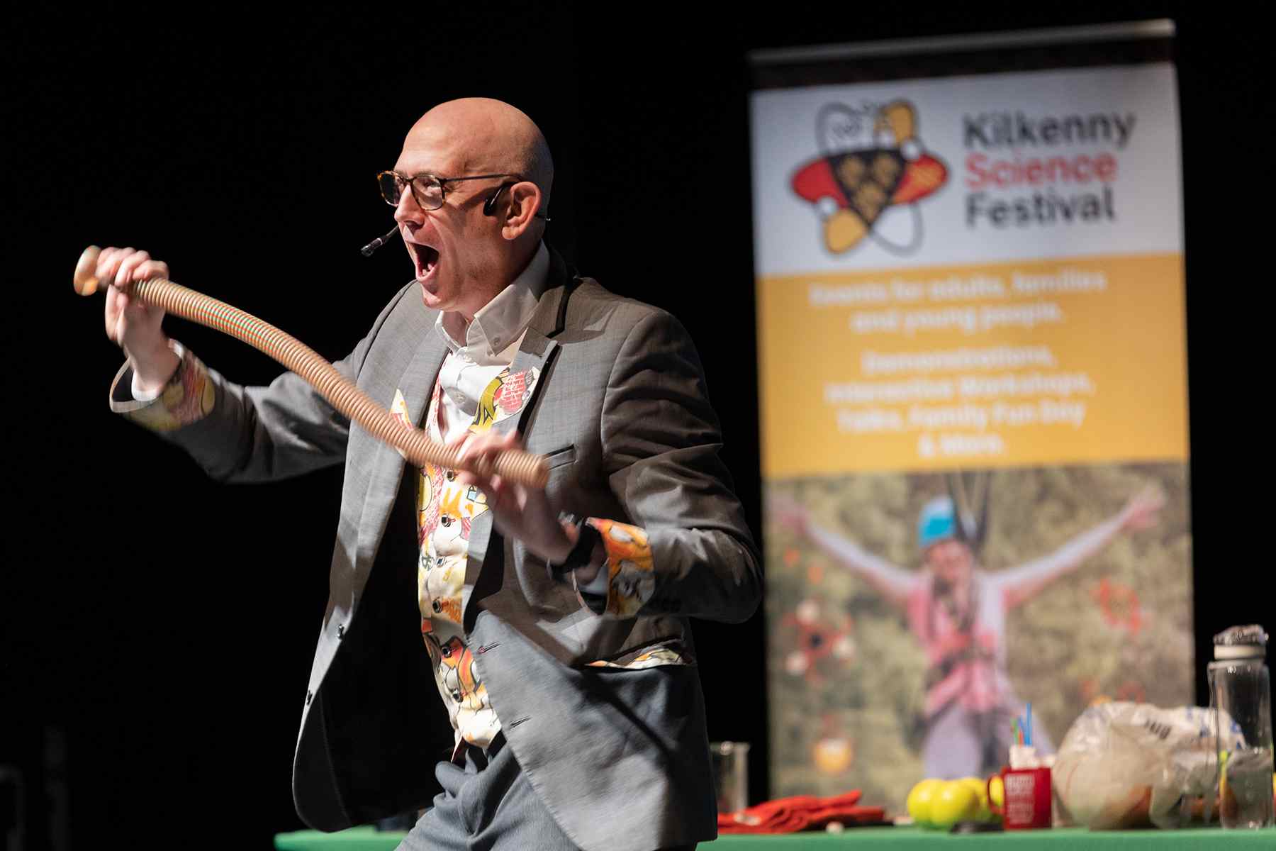 Dr Ken holds a long plastic flexi hose to explain polymerization